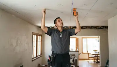 Electrician in Long Beach, CA maps recessed lighting positions with a stud finder and chalk line