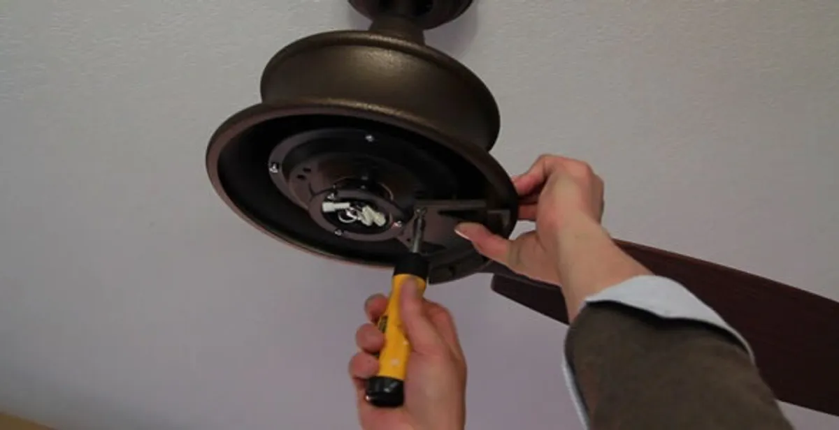 Electrician installing ceiling fan mounting bracket and fixture in Long Beach, CA