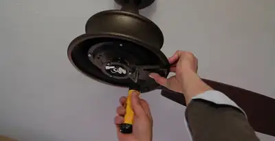 Electrician installing ceiling fan mounting bracket and fixture in Long Beach, CA