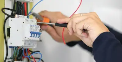 Electrician installing and adjusting circuit breakers in an electrical panel in Long Beach, CA