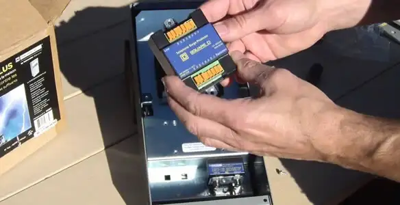Electrician installing whole home surge protection unit inside main electrical panel in Long Beach, CA