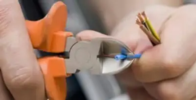 licensed electrician performing precise wire cutting and preparation during electrical service in Long Beach, CA