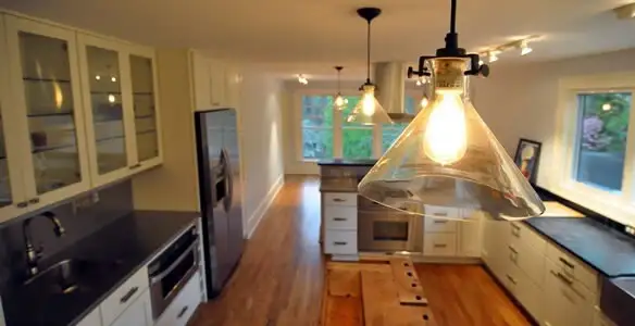 Residential electrician installing modern indoor light fixture in a home in Long Beach, CA